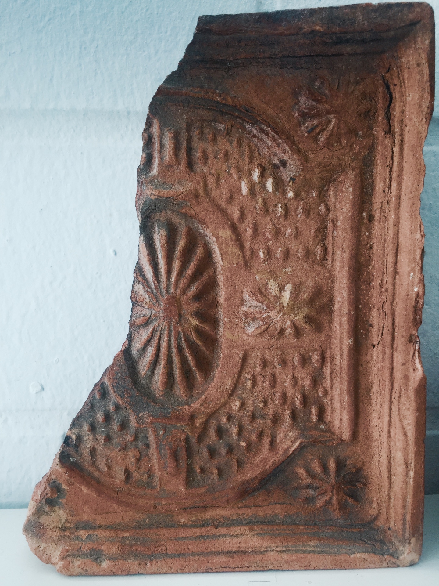 Fragment of an ornamented terracotta stove tile recovered on site